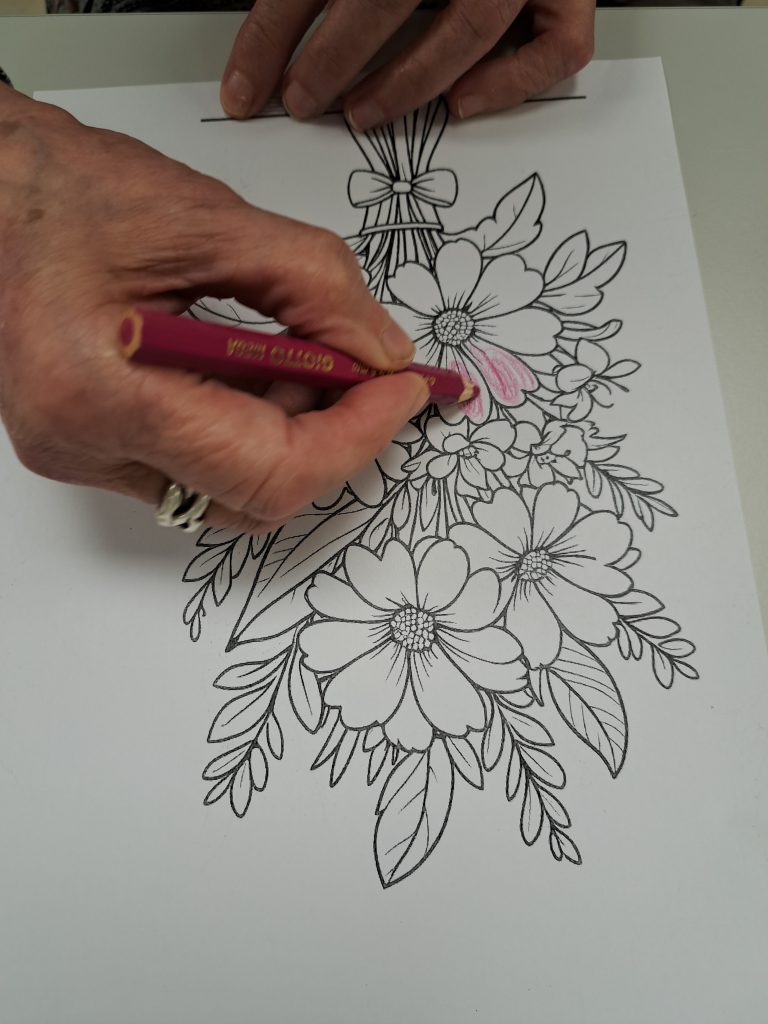 Na sliki je vidna roka med aktivnostjo barvanja.