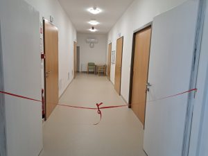 Na sliki je pogled na hodnik s štirimi vrati.