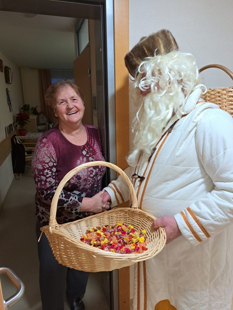 Na sliki je Dedek Mraz in vesela gospa.