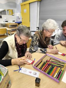 Slika prikazuje dve stanovalki, ki barvata knjižna kazala.